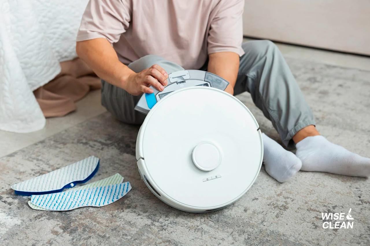 WiseClean – Person maintaining a robot vacuum cleaner on the floor